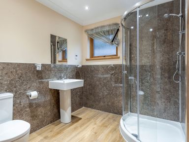 A bathroom with a toilet, sink, and shower at Rainbow Spa Plus (Pet) in Dundee