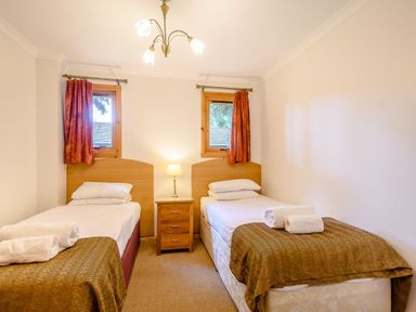 A bedroom with two single beds and a bedside table at Osprey Lodge in Dundee