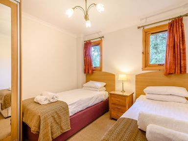 A bedroom with two beds and a bedside table at Osprey Lodge in Dundee