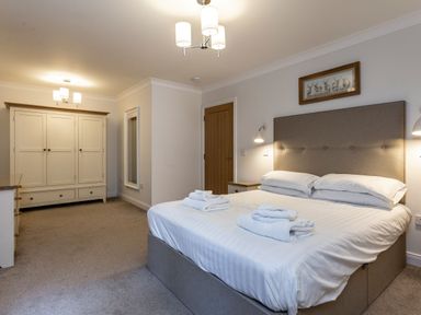 A bedroom with a bed and wardrobe at Galbraith Premier Spa in Dundee
