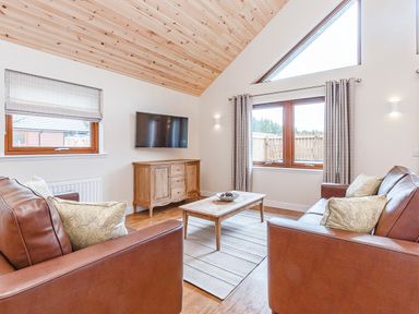 A living room with a television and coffee table at Galbraith Premier Spa in Dundee