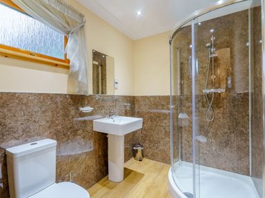 A bathroom with a shower and sink at Osprey Spa Plus in Dundee