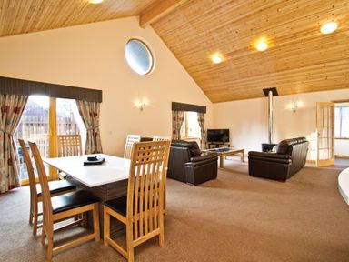 A living room with a dining area and seating at Osprey Spa Plus in Dundee