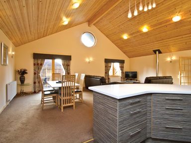 A living room with a dining area and sofa at Osprey Spa Plus in Dundee