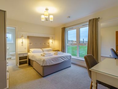 A bedroom with a bed and desk at Lochside Premier Spa in Dundee