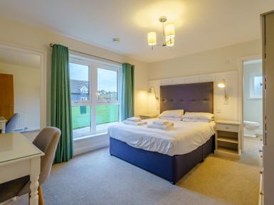 A bedroom with a bed and desk at Lochside Premier Spa in Dundee