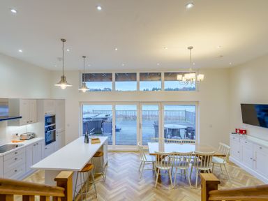 A kitchen with a dining area and large windows at Lochside Premier Spa in Dundee