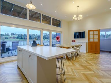 A kitchen with island and dining table at Lochside Premier Spa in Dundee