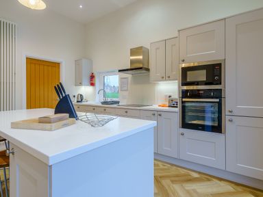 A kitchen with cabinets and appliances at Lochside Premier Spa (Pet) in Dundee