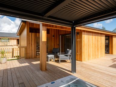 An outdoor area with a hot tub and chairs at Moonlight Spa Luxury in Waltham