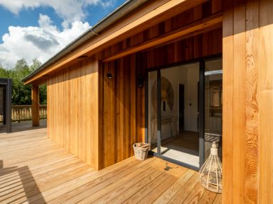 An outdoor patio with wooden walls and a glass door at Moonlight Spa Luxury Waltham