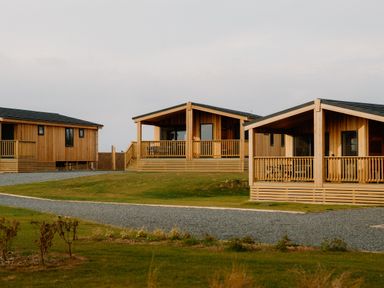 Wood cabins with porches and gravel path in the outdoor area at Luxury One Bedroom Retreat, Waltham