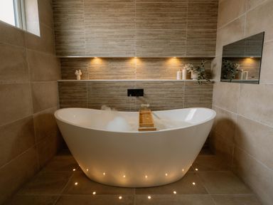 A bathroom with a bathtub and candles at Luxury One Bedroom Retreat in Waltham