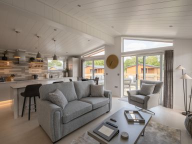 A living room with a sofa and kitchen area at The Luxury Hideaway in Waltham