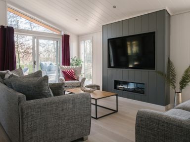 A living room with a television and sofa at The Luxury Hideaway in Waltham