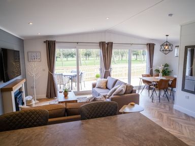A living room with a dining area and large windows at Dovecote in Waltham