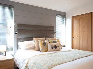 A bedroom with a bed and decorative pillows at Dovecote in Waltham