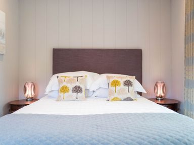 A bedroom with a bed and decorative pillows at The Henley in Waltham