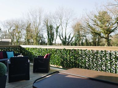 An outdoor seating area with furniture and hot tub at The Henley in Waltham