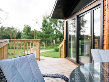 An outdoor space with a table and chairs on the decking at Macosi in Waltham