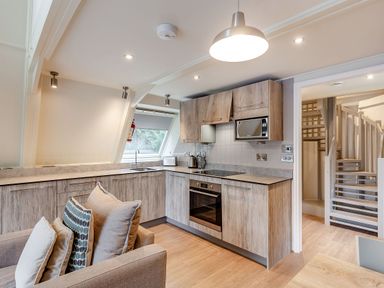 A kitchen with cabinets, sink, and appliances at St Ives Studio Spa in Praze-An-Beeble
