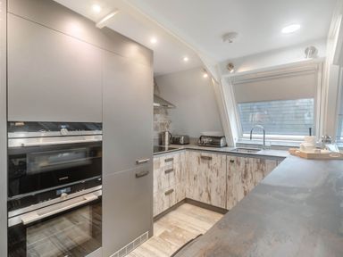A kitchen with appliances and cabinets at Glass Lodge in Praze-An-Beeble