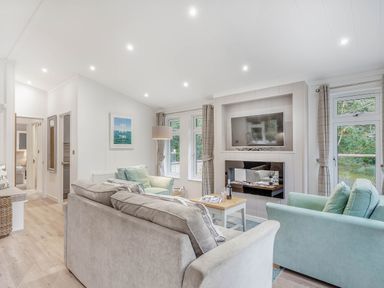 A living room with sofa and television at Aubyn Lodge Spa in Praze-An-Beeble