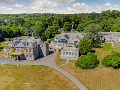 An aerial view of a large estate with multiple buildings and greenery at Aubyn Lodge Spa in Praze-An-Beeble
