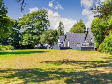 An outdoor area with cabins and trees at Aubyn Lodge Spa, Praze-An-Beeble