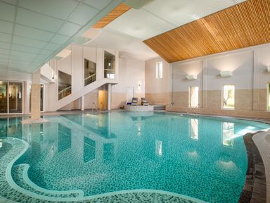 An indoor pool with steps and seating area at Aubyn Lodge Spa in Praze-An-Beeble