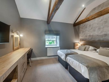 A bedroom with two beds and a desk at Coach House in Praze-An-Beeble