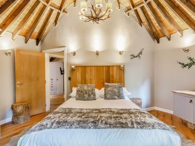 A bedroom featuring a bed, bedside table, and wooden elements at The Treehouse in Praze-An-Beeble