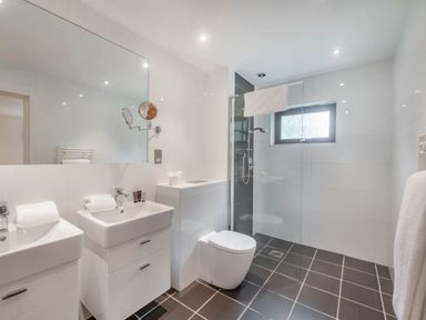 A bathroom featuring sinks, a toilet, and a shower at Cornwall Lodge Spa in Praze-An-Beeble