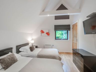 A bedroom with two beds and a window at Cornwall Lodge Spa in Praze-An-Beeble