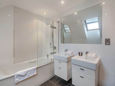A bathroom with a bath tub and two sinks at Cornwall Lodge Spa in Praze-An-Beeble