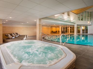 A spa area with a jacuzzi and lounge chairs at St Austell Lodge Spa in Praze-An-Beeble