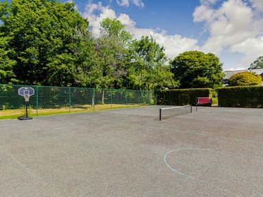 An outdoor sports area with a basketball hoop and tennis net at St Austell Lodge Spa in Praze-An-Beeble