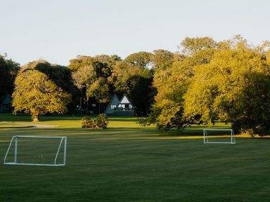 An outdoor field with goalposts and trees at St Austell Lodge Spa in Praze-An-Beeble