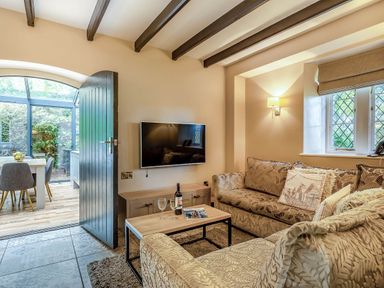 A living room with a sofa and a television at The Gatehouse in Praze-An-Beeble