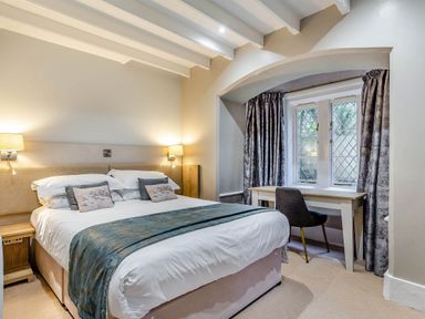 A bedroom with a bed and desk at The Gatehouse in Praze-An-Beeble