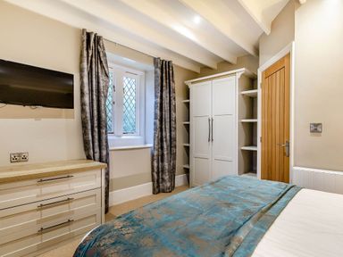 A bedroom with a television and wardrobe at The Gatehouse in Praze-An-Beeble