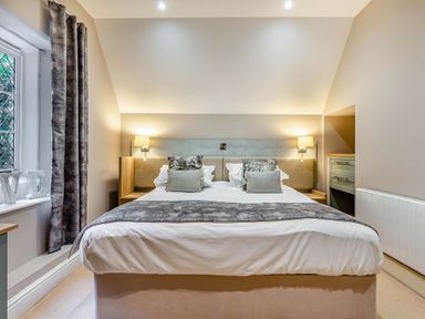 A bedroom with a bed and bedside lamps at The Gatehouse in Praze-An-Beeble