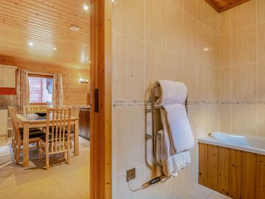 A dining room with a table and chairs at Woodland Lodge Spa in Praze-An-Beeble