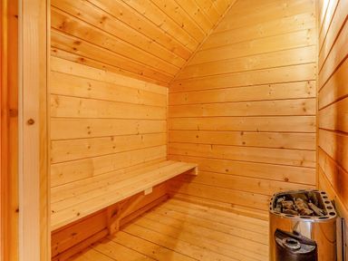 A sauna with wooden walls and a wooden bench at Woodland Lodge Spa in Praze-An-Beeble