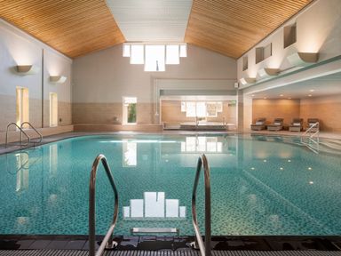 An indoor pool area with a swimming pool and lounge chairs at Woodland Lodge Spa in Praze-An-Beeble