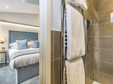 A bathroom with a shower and towels at Lake View Spa in Praze-An-Beeble