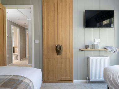 A bedroom with a wardrobe and television at Argel Spa in Praze-An-Beeble