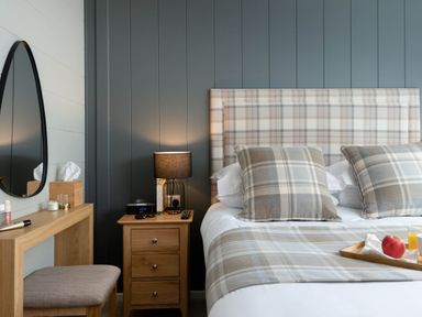 A bedroom with a bed, nightstand, and mirror at Argel in Praze-An-Beeble