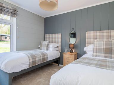 A bedroom with twin beds and a bedside table at Argel in Praze-An-Beeble