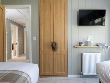 A bedroom with a wardrobe and TV at Argel in Praze-An-Beeble